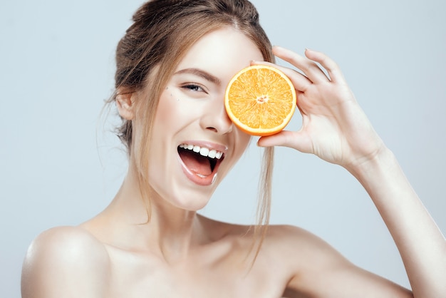 Beautiful woman face with juicy orange