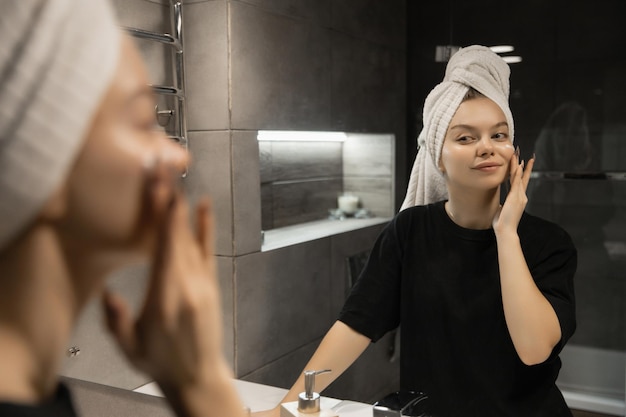 Beautiful woman for facial skin care applies cream on the skin