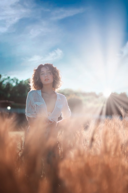 Beautiful woman in a field at sunset