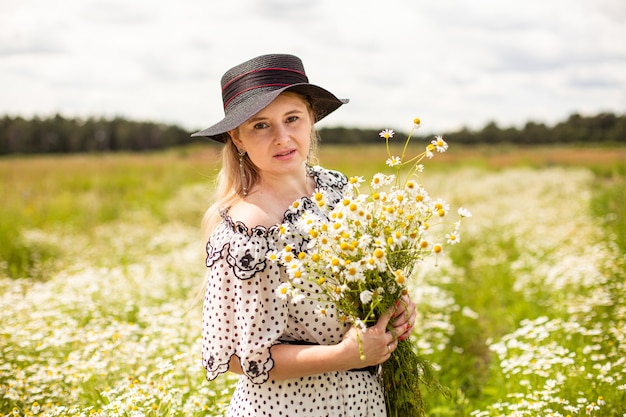 Beautiful woman in the field with flowers. High quality photo