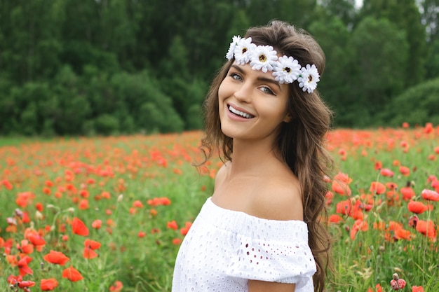 Beautiful woman in field with a lot of poppy flowers