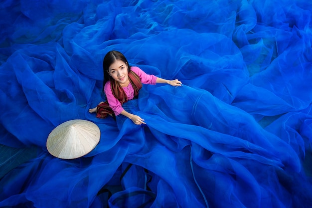 Beautiful woman fisherman is repairing fishing nets, Fisherman is cleaning Thai fishing ne