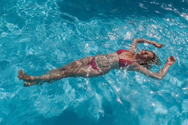 Beautiful woman floating in a swimming pool