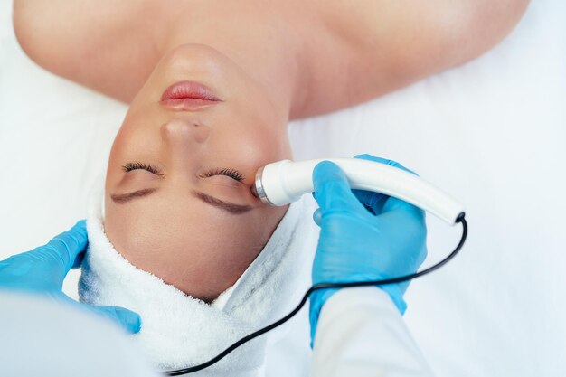 Bella donna che riceve un trattamento per la cura della pelle del viso in una clinica di bellezza cosmetica