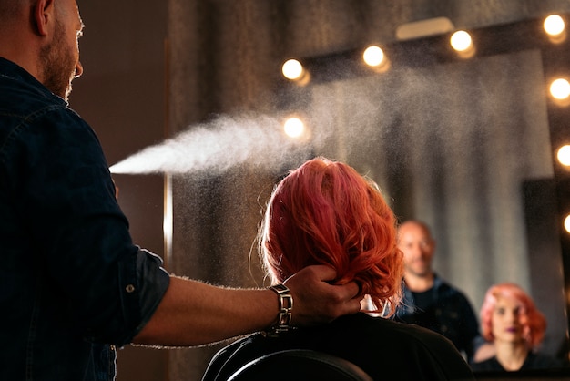 Beautiful woman getting haircut by hairdresser.