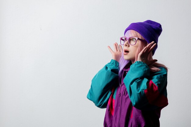 Beautiful woman in glasses and 80s sportsuit on white background