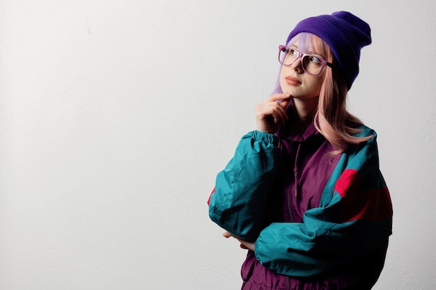 Beautiful woman in glasses and 80s sportsuit on white background