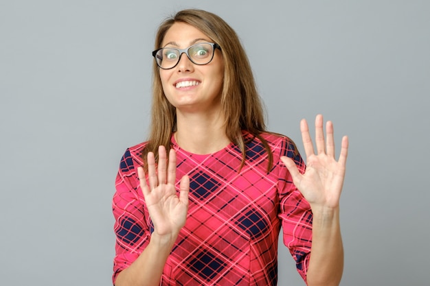 Beautiful woman over gray background afraid and terrified