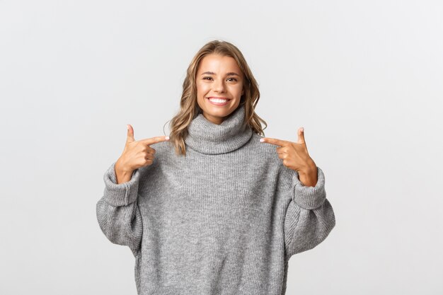 Beautiful woman in a grey sweater posing