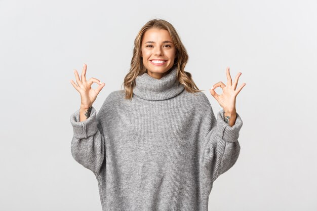 Beautiful woman in a grey sweater posing