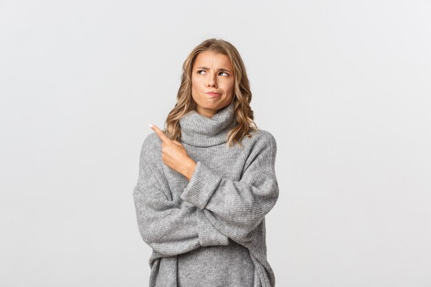 Beautiful woman in a grey sweater posing