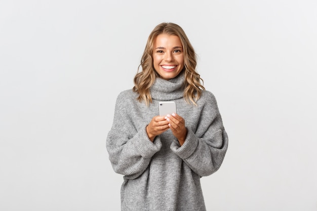 Beautiful woman in a grey sweater posing