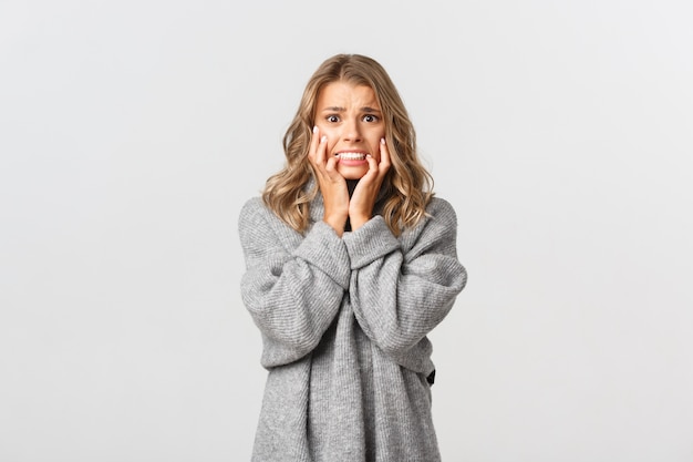 Beautiful woman in a grey sweater posing