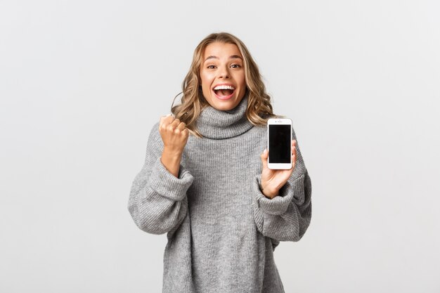 Beautiful woman in a grey sweater posing