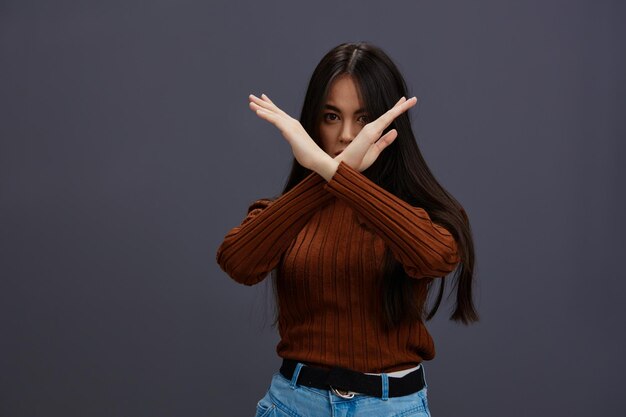 Beautiful woman hand gestures brown sweater fashion gray\
background