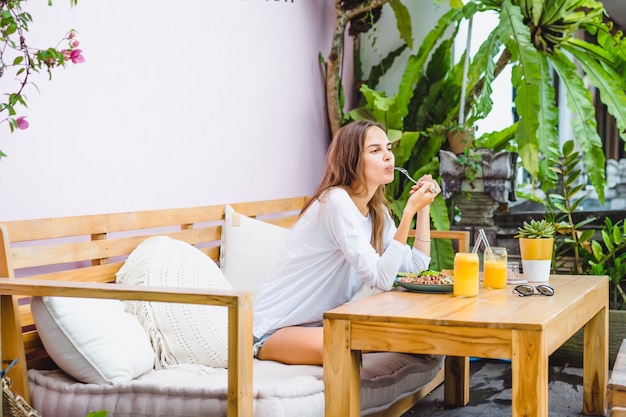 A beautiful woman has breakfast in a stylish cafe