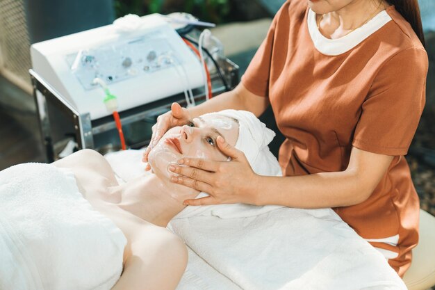 写真 スパで顔マスクでマッサージをしている美しい女性 静けさ