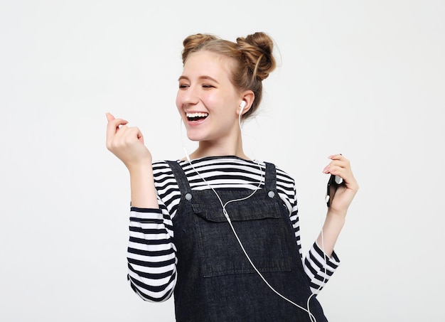 Beautiful woman in headphones listening to music on white background