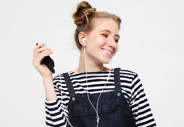 Beautiful woman in headphones listening to music on white background