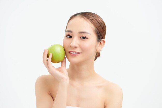 Beautiful woman holding an apple and smiling