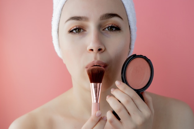 Beautiful woman holding blush brush