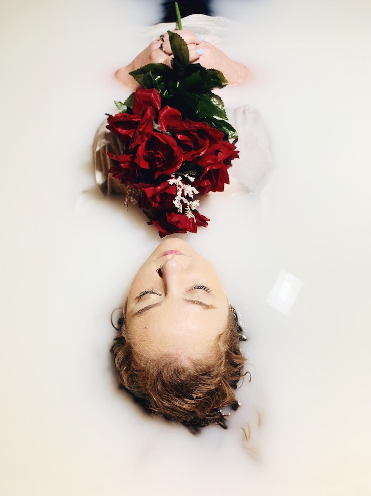 Photo beautiful woman holding bouquet in bathtub