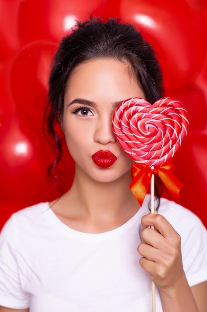 Photo beautiful woman holding candy heart