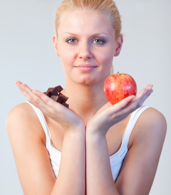 Beautiful woman holding chocolate and apple focus on woman 