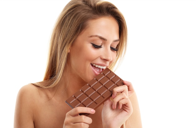 Bella donna che tiene cioccolato su bianco