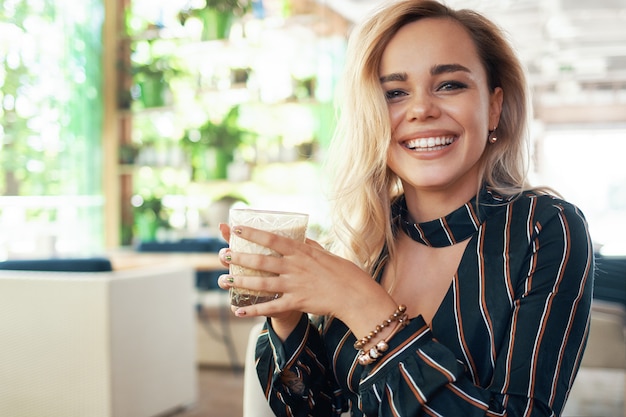 beautiful woman holding a cocktail in her hands