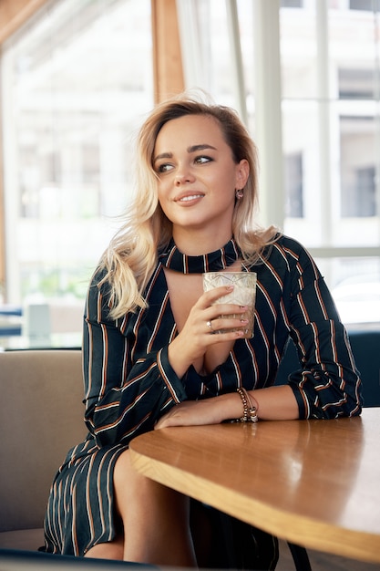 Beautiful woman holding a cocktail in her hands