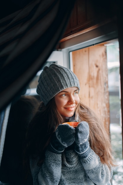 一杯のコーヒーを保持し、飲む美しい女性