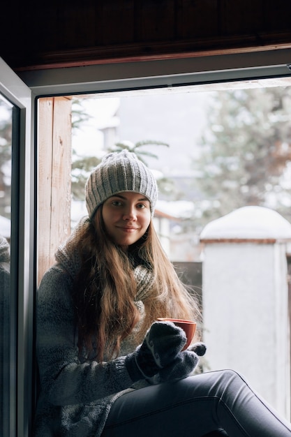 Bella donna che tiene e che beve una tazza di caffè