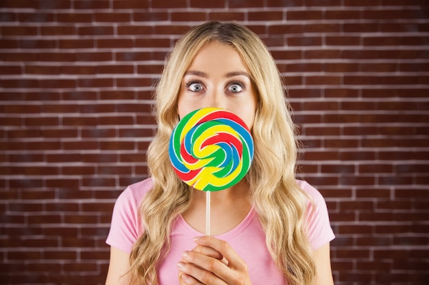 A beautiful woman holding a giant lollipop 