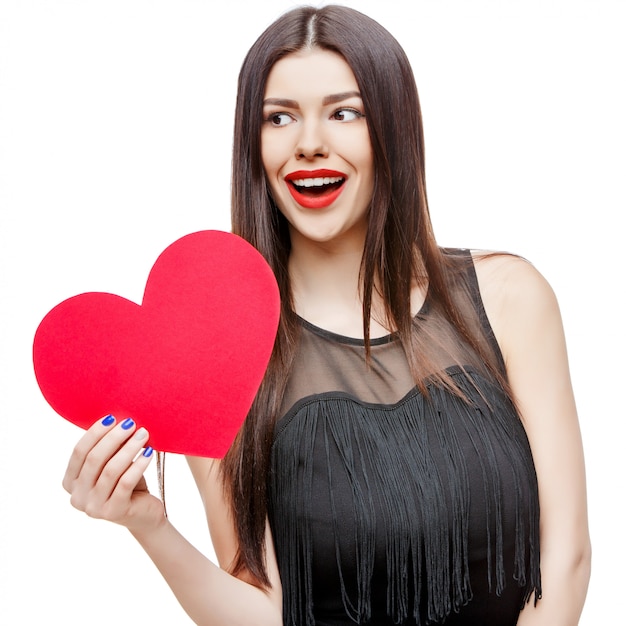 Beautiful woman holding heart shaped valentine card and smiling