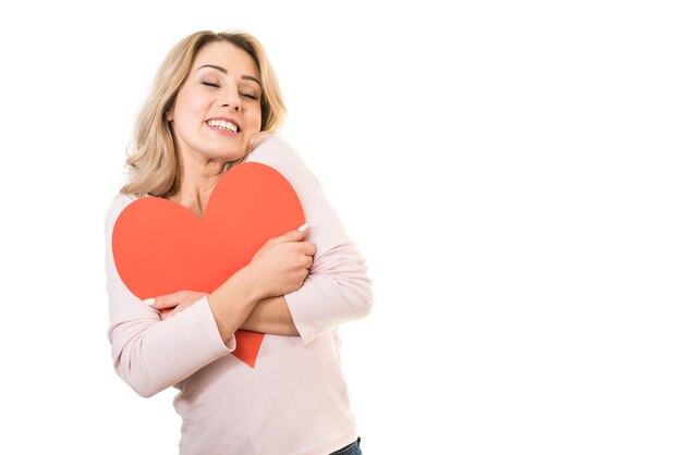 The beautiful woman holding a heart symbol on the white background