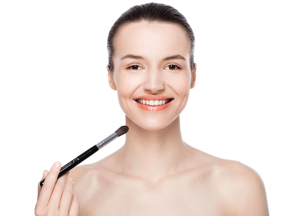 Beautiful woman holding makeup brush foundation