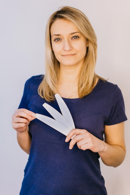 Beautiful woman holding a manicure accessories in hand on white