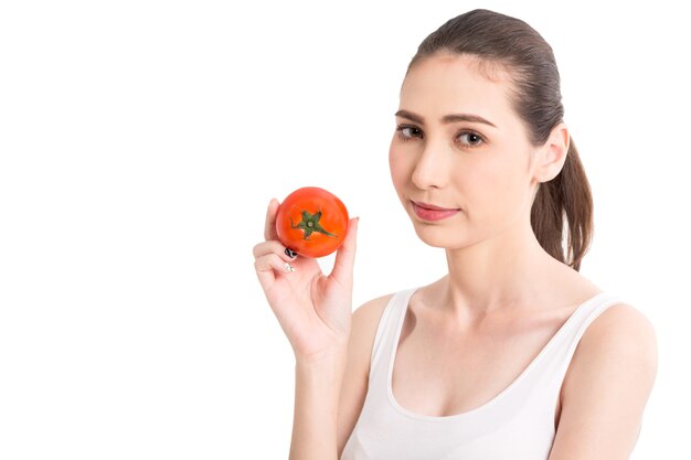 Beautiful woman holding a red tomato isolated on white background