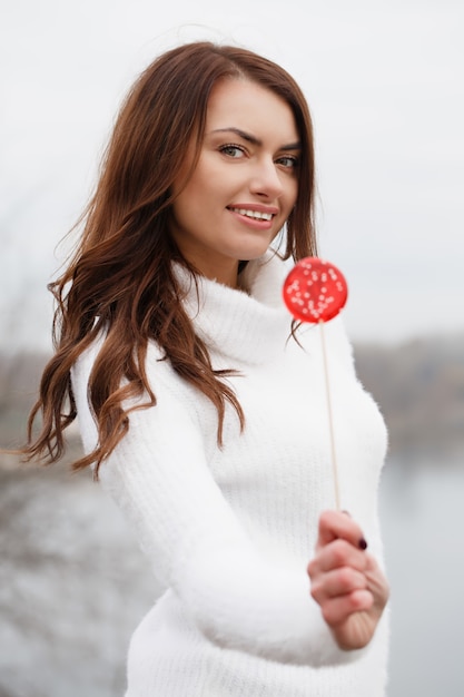 Beautiful woman holds a lollipop