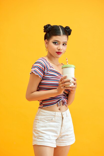 A beautiful woman holds a takeaway cup of coffee