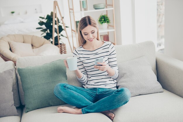 Beautiful woman at home using smartphone