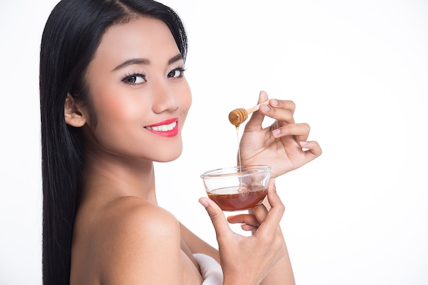 Beautiful woman and honey on white background