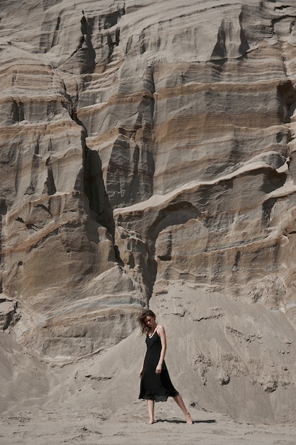 사진 검은 드레스에서 아름 다운 여자는 모래 산 근처 포즈. 자연, 아름다운 메이크업 패션 여자