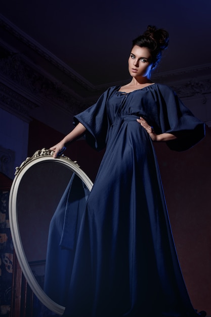 Фото Красивая женщина в голубом платье с зеркалом