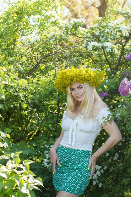 写真 春の黄色い花の花束をかぶった美しい女性 庭園 柔らかい焦点