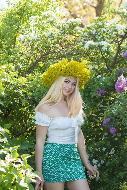 写真 春の黄色い花の花束をかぶった美しい女性 庭園 柔らかい焦点