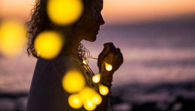 写真 黄色の電球のライトと影の美しい女性