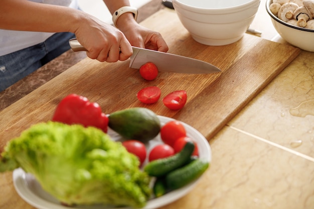 美しい女性が自宅の台所でおいしい料理を作っている
