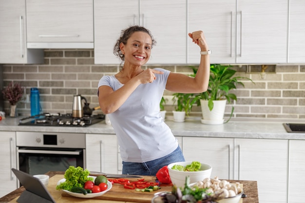 Beautiful woman is cooking delicious dishes at her home kitchen